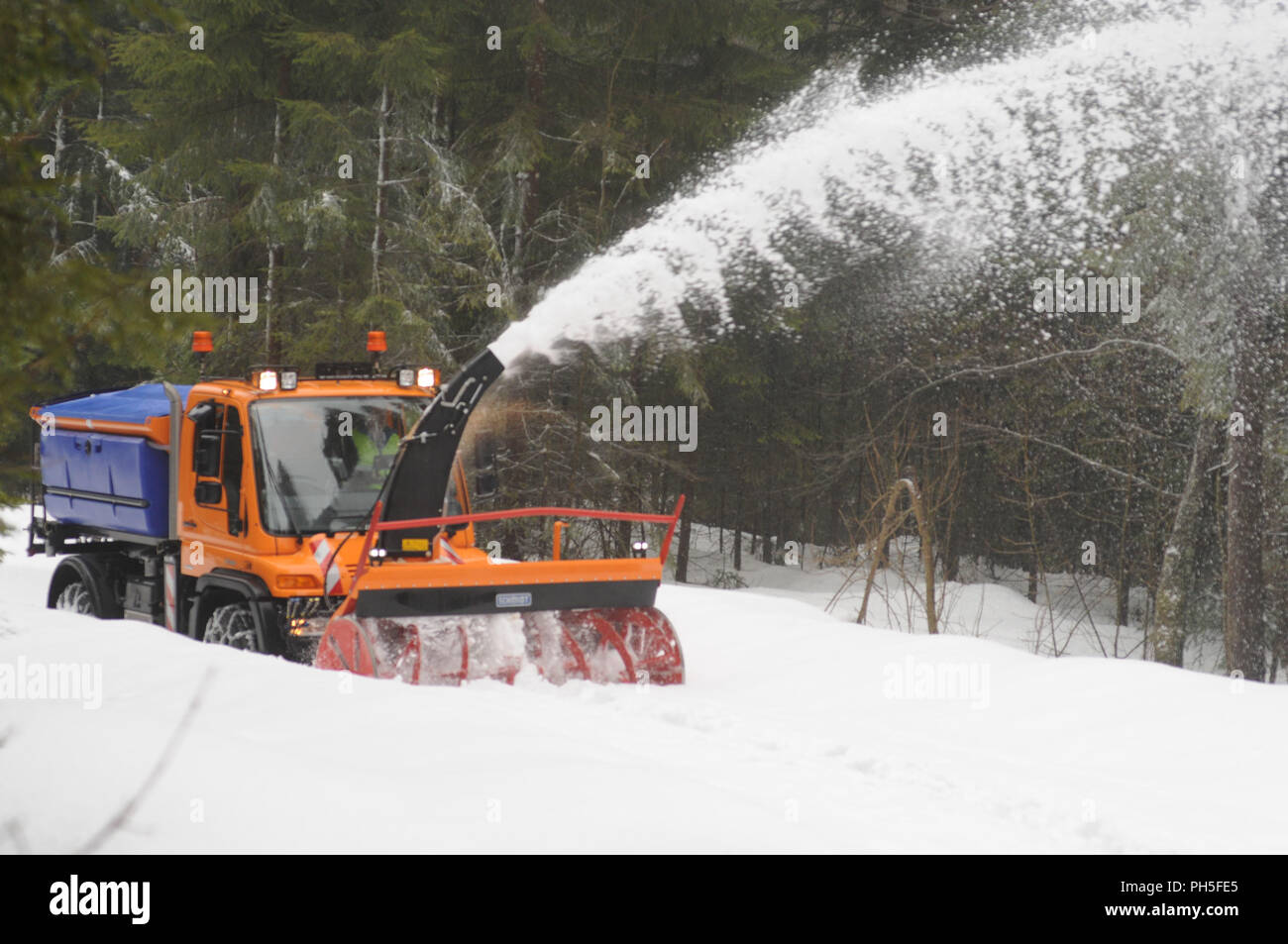 Schnee Fräsmaschine bei der Arbeit Reinigung eine Forststraße Stockfoto