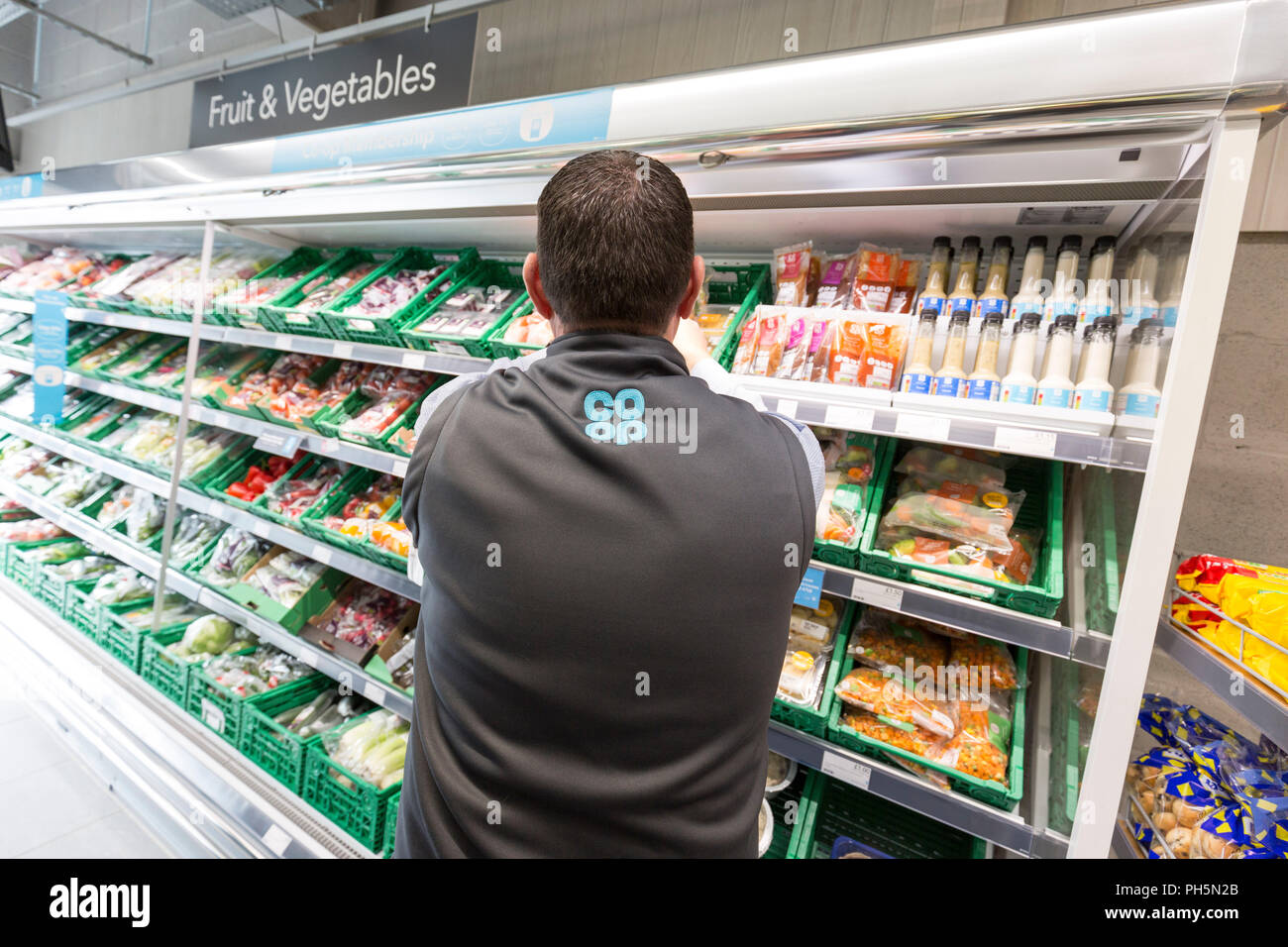 CoOp Lebensmittel Shop. Ein männlicher Arbeitnehmer Stapeln Regale Stockfoto