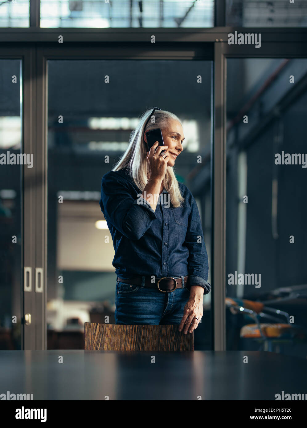 Portrait von Senior Business Frau, im Büro und im Gespräch über das Telefon. Weibliche Unternehmer ein Telefonanruf. Stockfoto