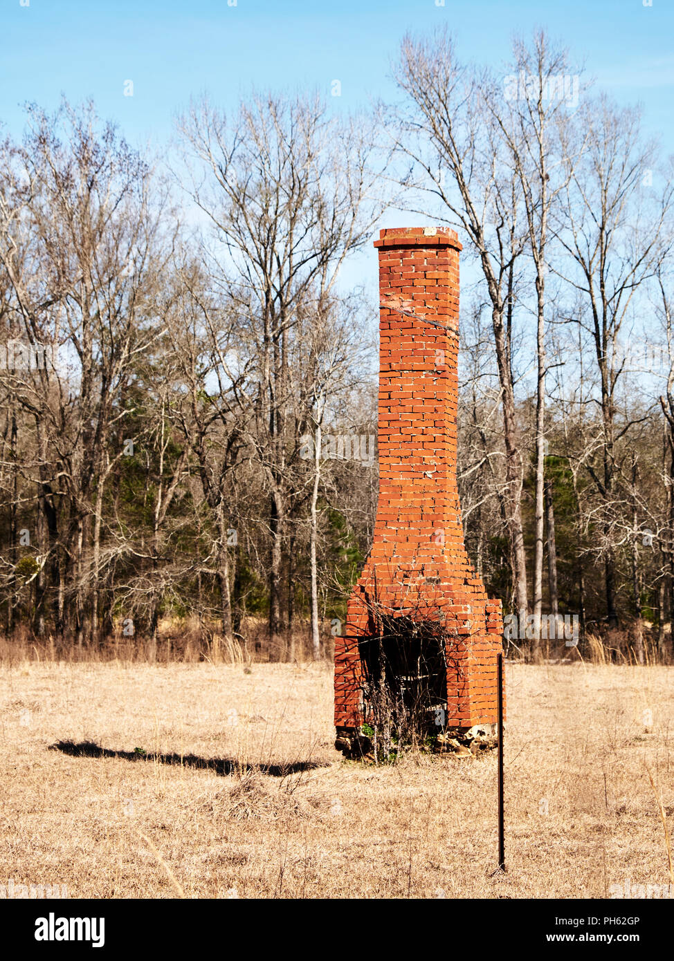 Alten rustikalen Backstein einsames Haus Schornstein links steht in einem Feld in Alabama, USA. Stockfoto
