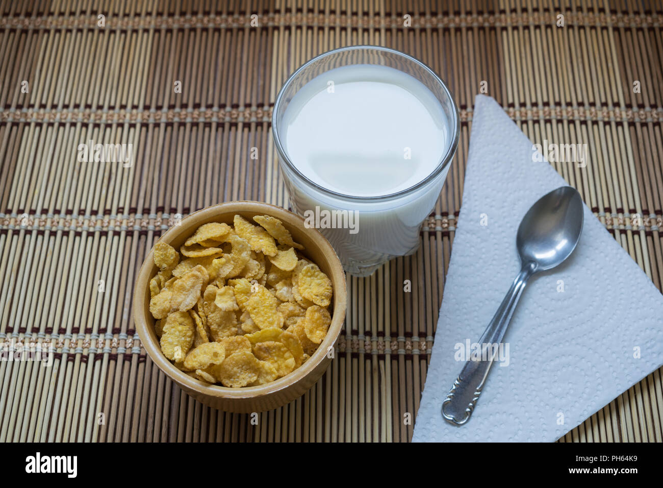 Cornflakes Müsli in eine Schüssel geben und mit einem Glas Milch begleitet. Eine gesunde und typische Frühstück Stockfoto