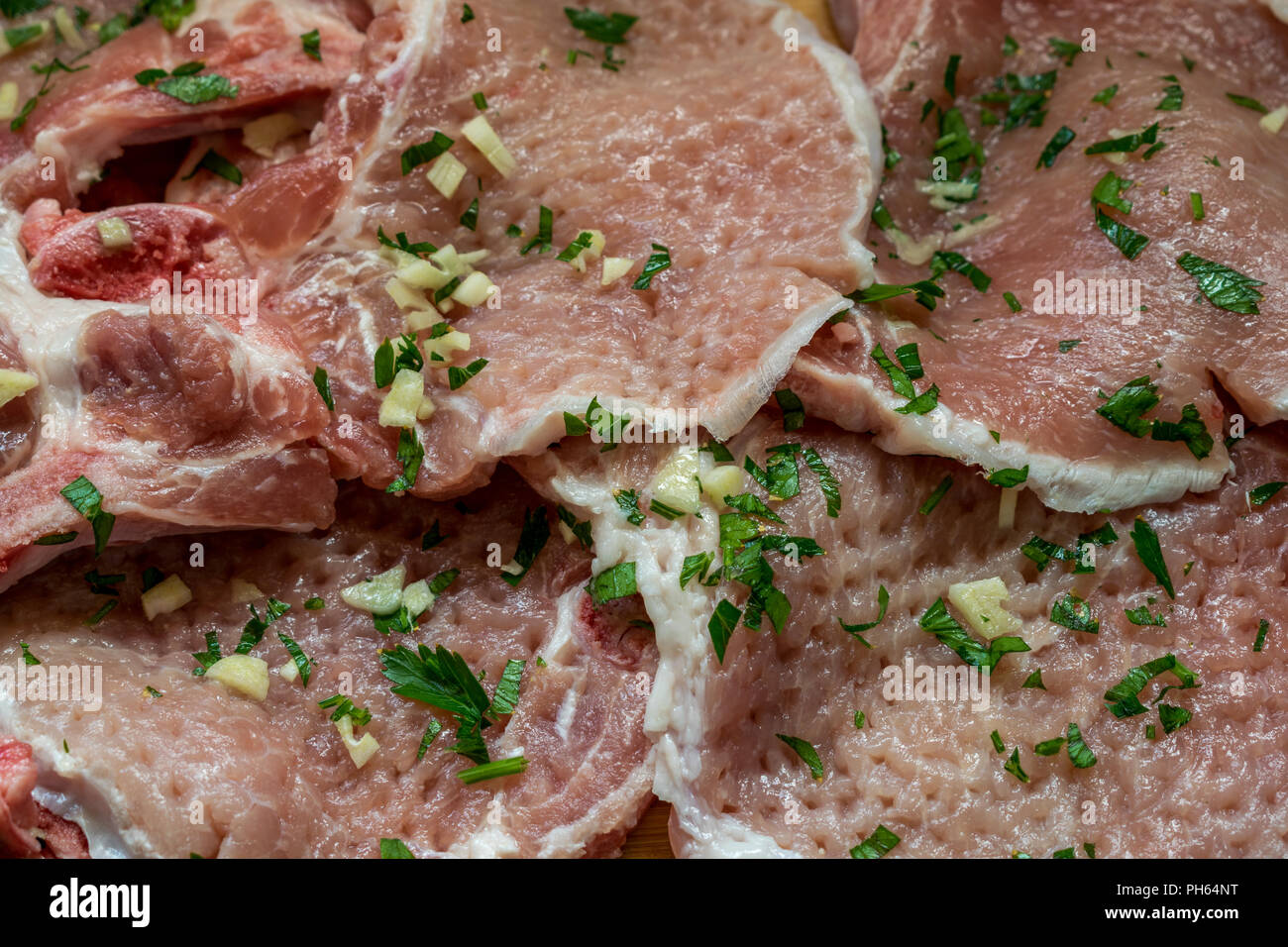 Rohes Schweinefleisch mit Petersilie und Knoblauch fein hacken. Bereit zum Kochen Stockfoto