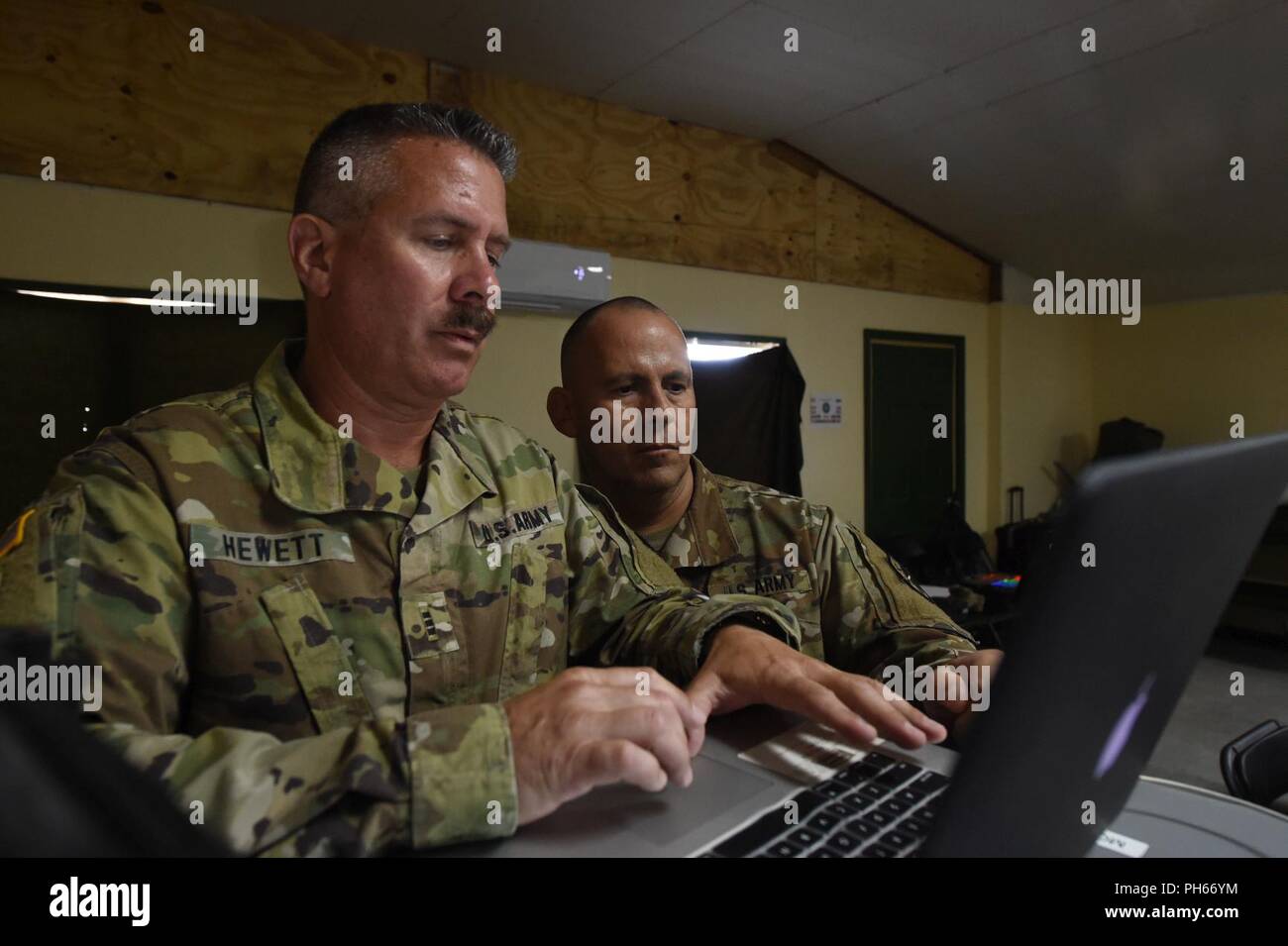 CORAL HARBOUR, Bahamas (19. Juni 2018) U.S. Army Chief Warrant Officer 3 Bob Hewett (links) und Sgt. 1. Klasse Shayne Chapman, die beide von der Rhode Island Army National Guard, Cyber Attack Management während der Simulationen diskutieren als Teil der Übung Tradewinds 2018. Tradewinds ist ein US Southern Command gesponsert Übung, die Teilnehmenden karibischen Nationen die Gelegenheit, Sicherheit und Disaster Response Fähigkeiten zu verbessern. Der Fokus liegt in diesem Jahr bei der Bekämpfung der grenzüberschreitenden organisierten Kriminalität in der Region. Stockfoto