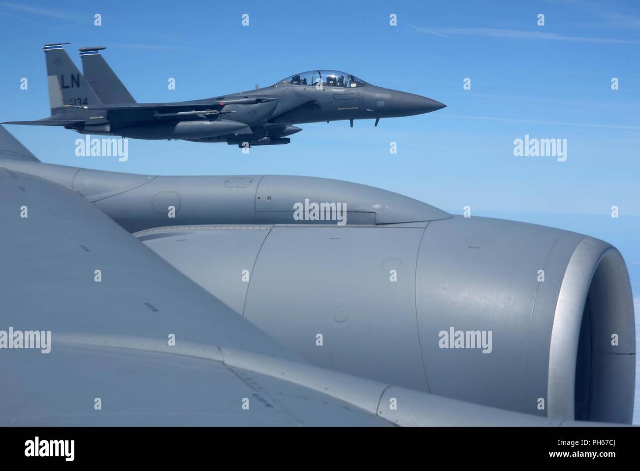 Ein US Air Force F-15E Strike Eagle vom 492Nd Fighter Squadron, RAF Lakenheath fliegt neben einem US Air Force KC-135 Stratotanker aus über England, 26. Juni 2018. Die ehrenamtlichen Kommandanten waren in der Lage, Zeugen die Luftbetankung, den Blutigen und Hundertstel RAF Lakenheath. Stockfoto