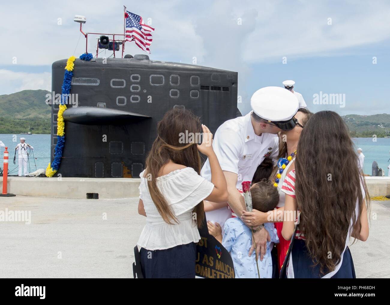 SANTA Rita, Guam (29. Juni 2018) Chief Elektronik Techniker Navigation Michael Levy erhält einen Kuss von Frau Crystal während ein homecoming Zeremonie auf der Pier für den Los-Angeles-Klasse schneller Angriff U-Boot USS Oklahoma City (SSN723), am 29. Juni. Oklahoma City ist eine von vier Vorwärts - Einsatz u-Boote zum Kommandanten, Submarine Squadron 15 zugewiesen. Stockfoto