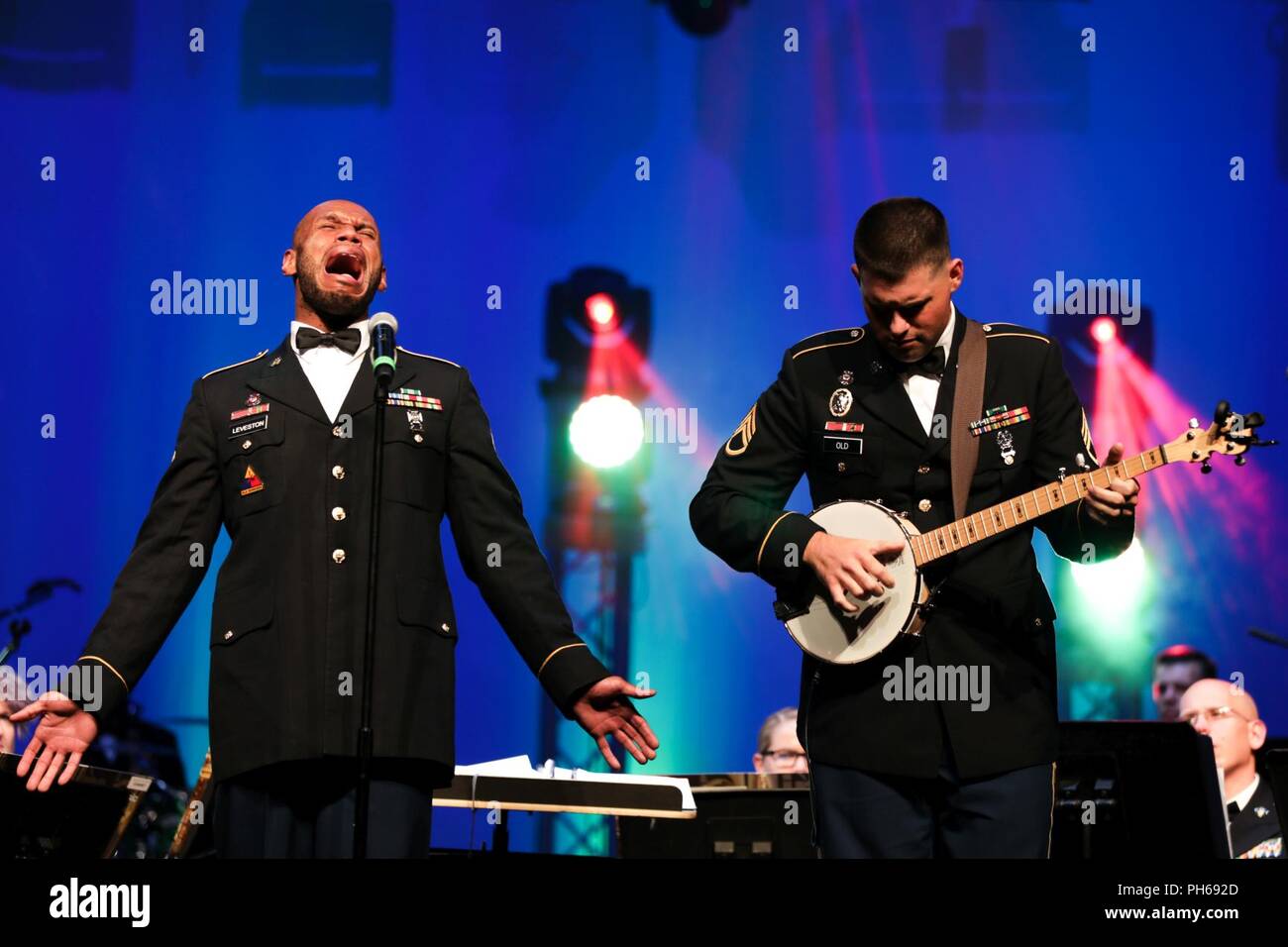 Us-Armee SPC. Joseph Leveston Sänger und Staff Sgt. James Alte am Banjo Soldaten, die in den 389 US-Army Material Command Band durchführen Banjo Musik der Tennessee Valley, Bob Jones an der High School, Alabama, 26. Juni 2018. Die AMC-Band zu einem verpackten Publikum während Ihrer letzten Konzert vor der Inaktivierung. Stockfoto