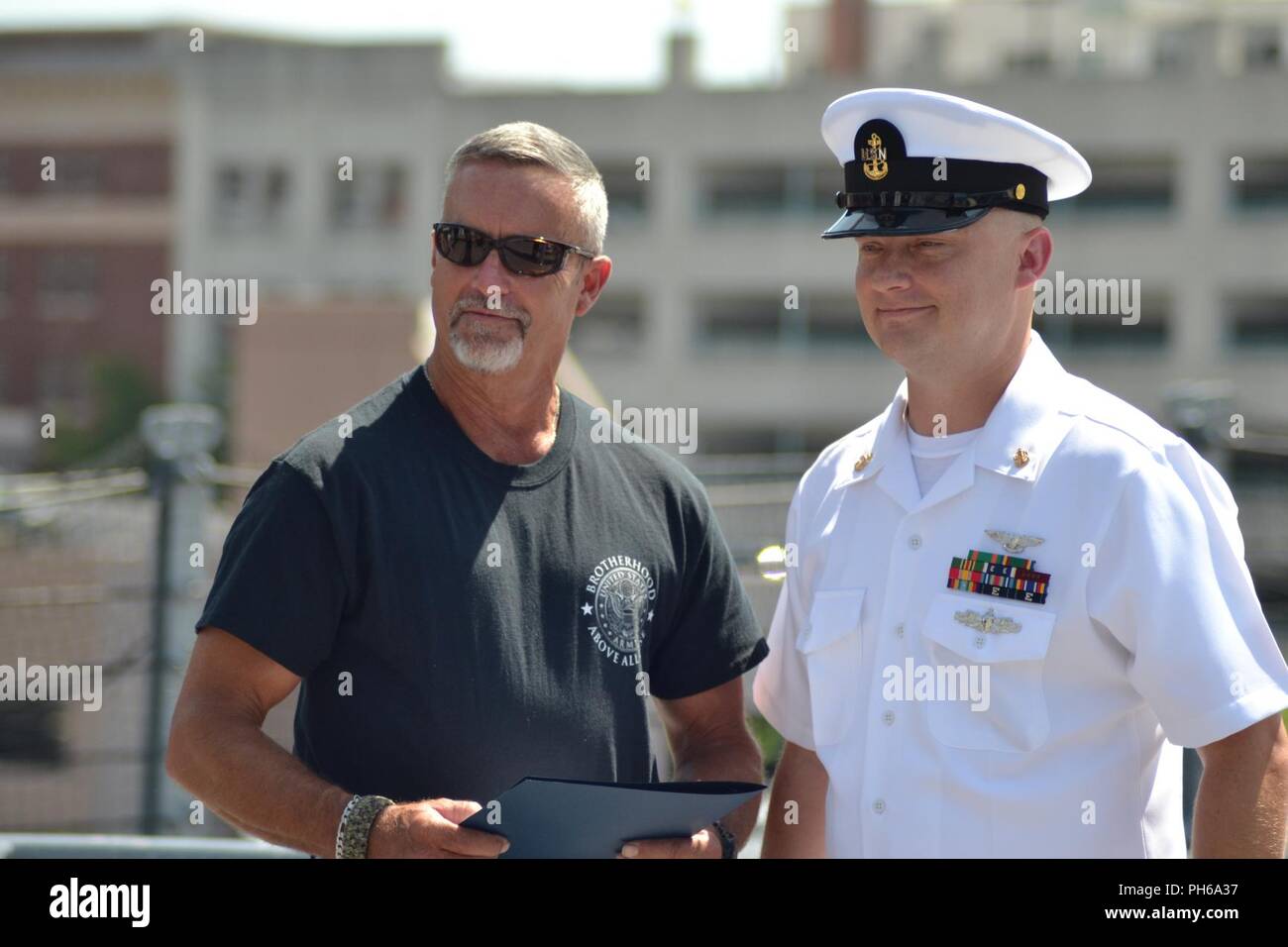 AOC Christopher Crabtree, von der USS Gerald R. Ford (CVN-78) steht mit einem Familienmitglied eine Bescheinigung der Anerkennung während seiner 57-Rekrutierung Zeremonie auf der USS Wisconsin. Die USS Wisconsin (BB-64) ist ein Iowa - Klasse Schlachtschiff, die ursprünglich im Jahr 1944 in Betrieb genommen. Da stillgelegt wird, hat neben dem Hampton Roads Naval Museum und Nauticus liegt in der Innenstadt von Norfolk, Virginia als Museumsschiff. Das Museum ist in der Lage, militärische Zeremonien, wie Re-enlistments, Promotions und Abgänge an Bord der legendären USS Wisconsin kostenlos. Interessierte Befehl Stockfoto