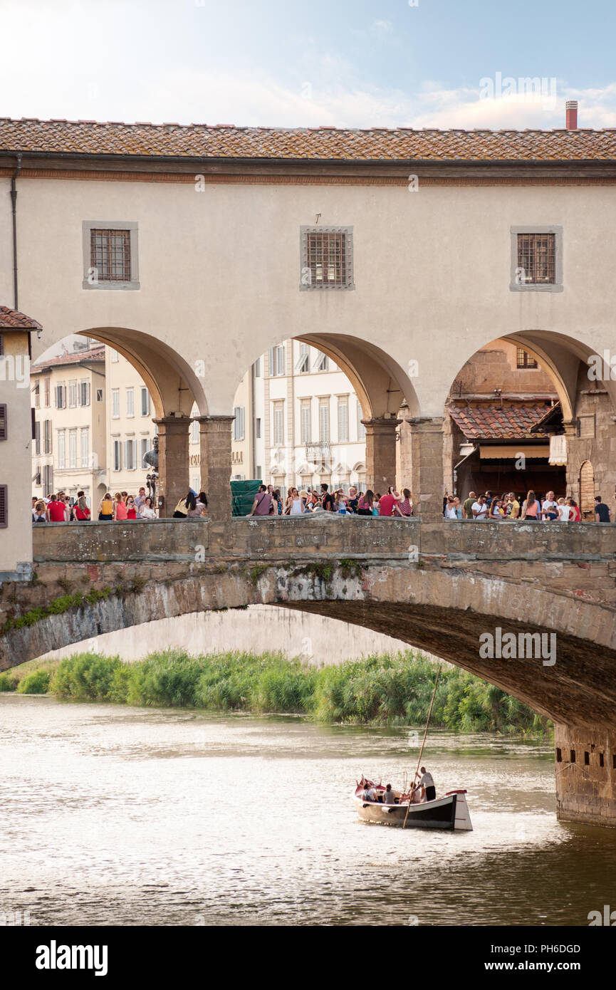 Florenz, Italien - 2018, 14. Juli: Segeln entlang des Arno Flusses; Touristen Masse der Brücke Ponte Vecchio in Florenz, Italien. Stockfoto