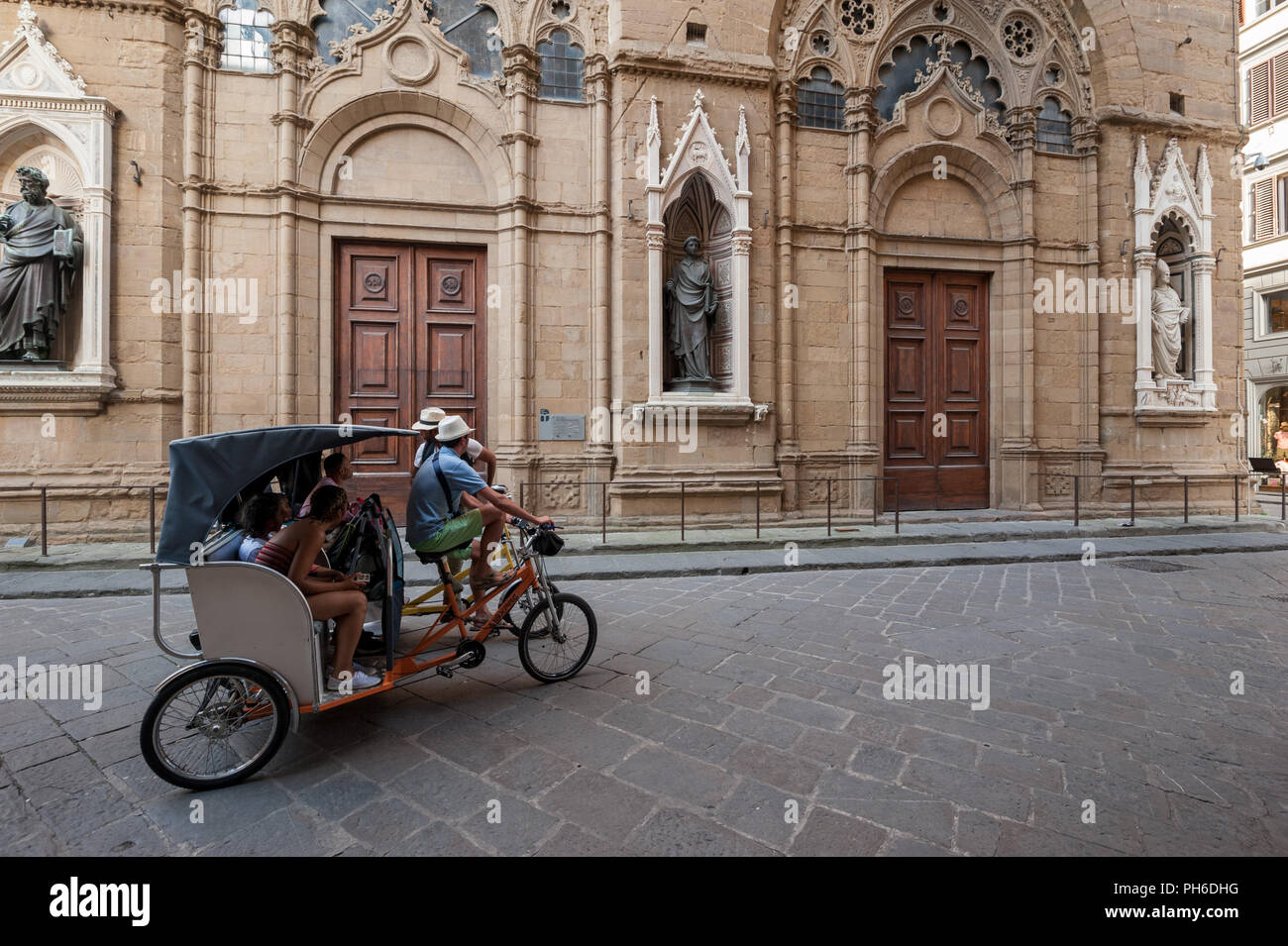 Florenz, Italien - 2018, 14. Juli: Touristen auf einer Sightseeing Tour, auf fahrradrikscha, Besuch von Orsanmichele Kirche, im historischen Zentrum von Florenz, Italien. Stockfoto