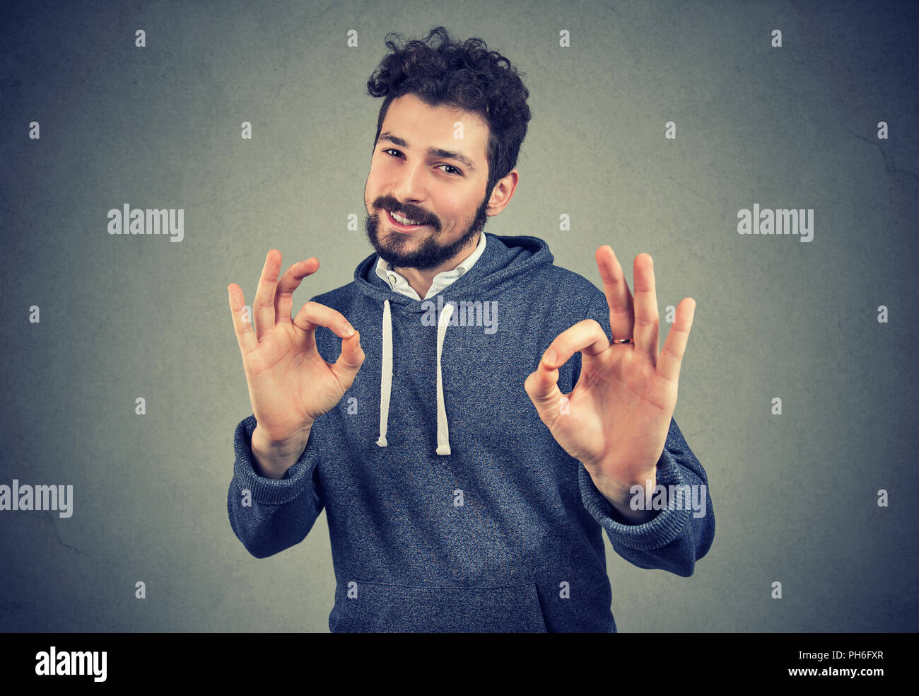 Jungen gutaussehenden Mann zuversichtlich zeigen ok Zeichen toll fühlen Stockfoto
