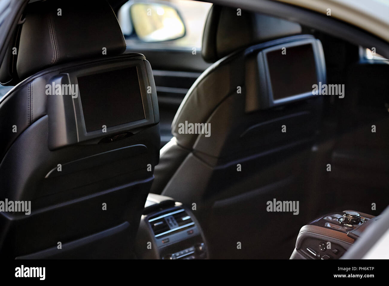 Auto innen. Innenraum der Prestige luxuriöses, modernes Auto. Zwei Anzeigen für die Rücksitze Passagier mit media control panel Kopieren space Mock up. Stockfoto