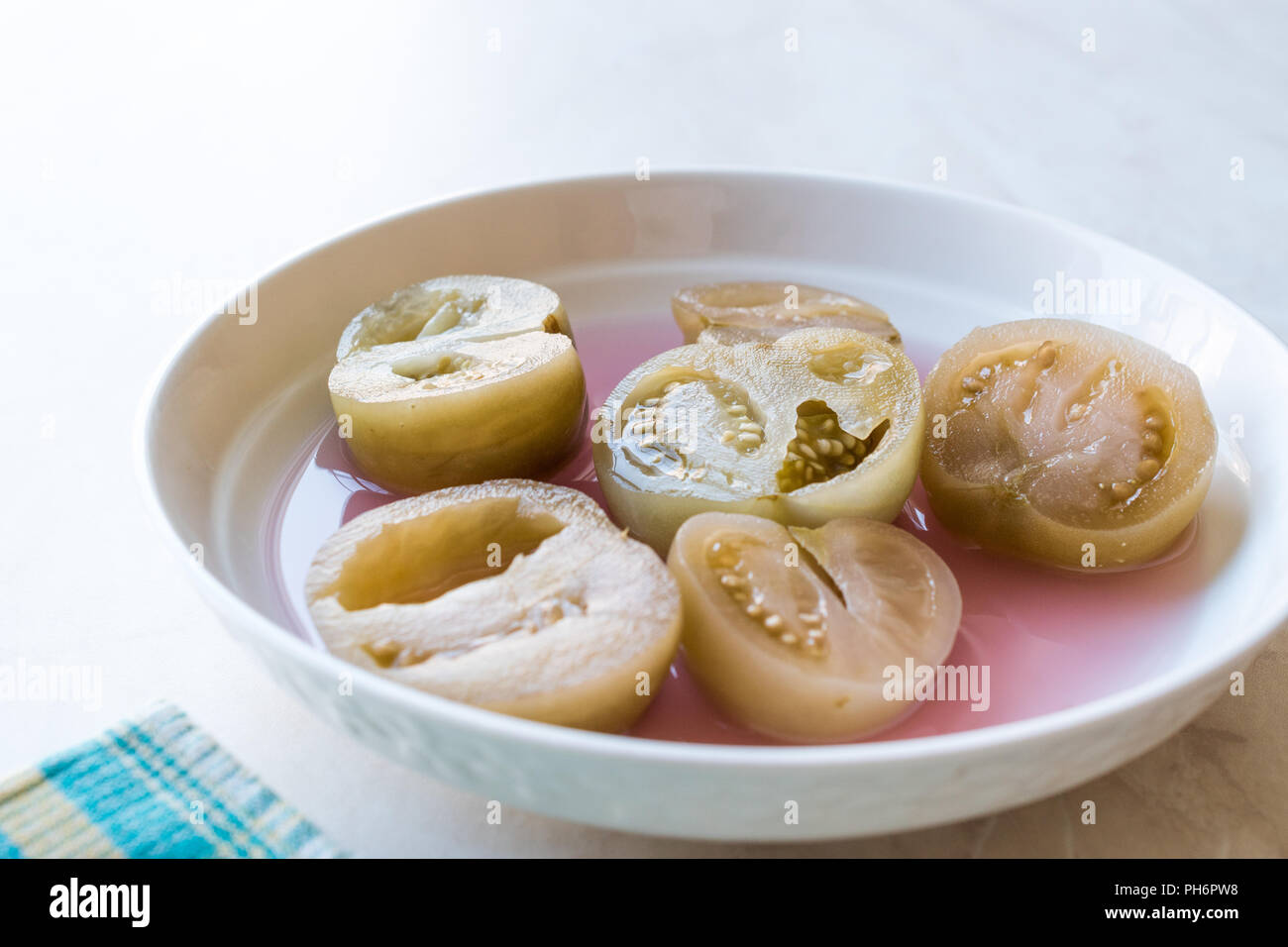 Cannned Grün Tomatenscheiben mit essiggurke Saft in Platte (die Hälfte erhalten und Gebeizt). Ökologische Lebensmittel. Stockfoto