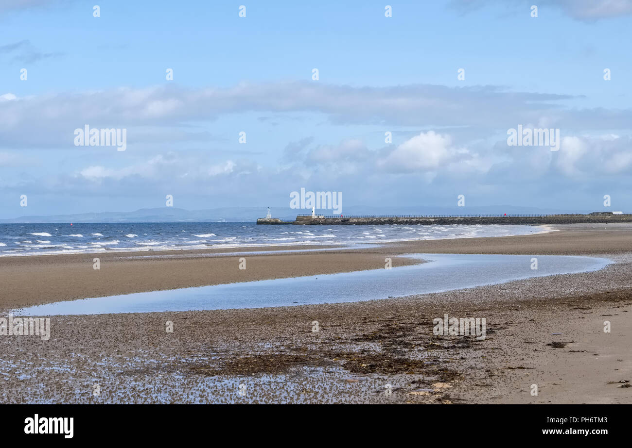 Auf der Suche nach Ayr Strand in Richtung des Lichts Haus und Meer Wand an einem hellen Tag im August. Stockfoto