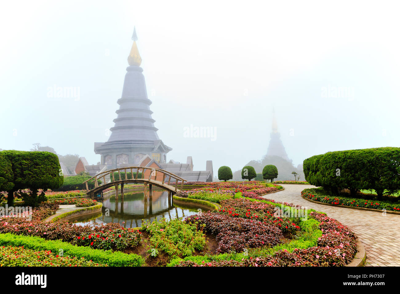 Blumengarten und Stupa im Morgennebel Stockfoto