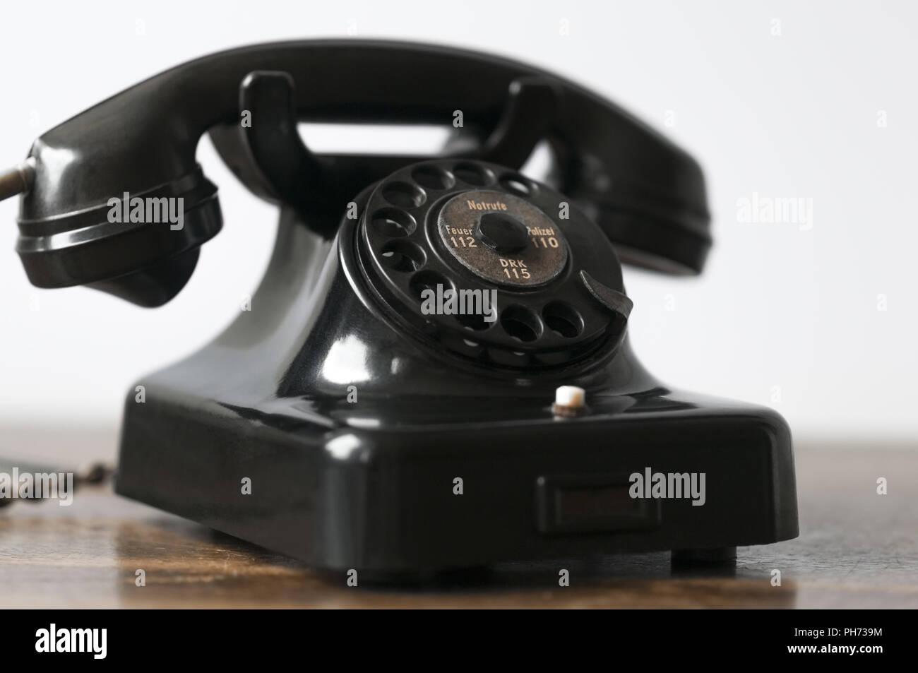 Alte schwarz Telefon auf einem Schreibtisch und weißen Hintergrund. Stockfoto