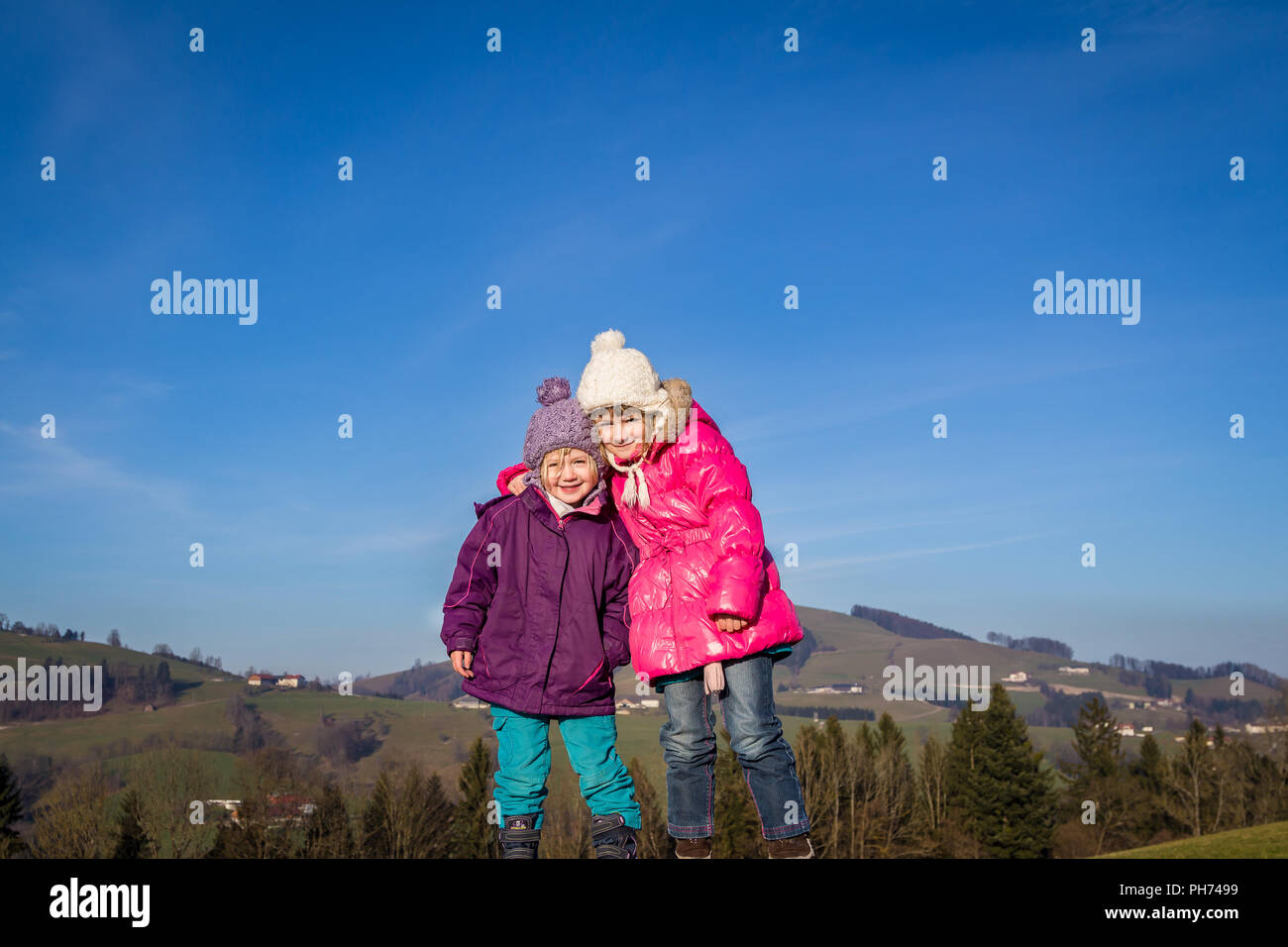 Zwei Mädchen mit Winterjacken und Bommel Hüte Stockfoto
