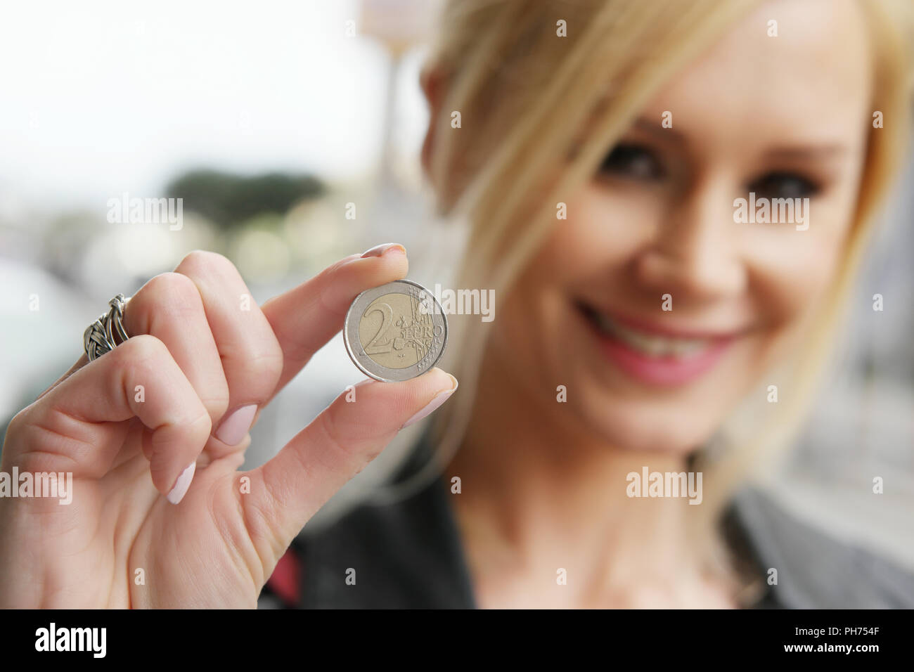 Frau, eine Münze in die Kamera Stockfoto