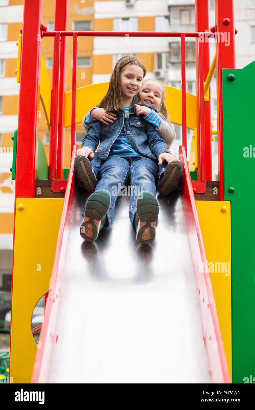 Mädchen Rutschen hinunter den Hügel auf dem Spielplatz Stockfoto