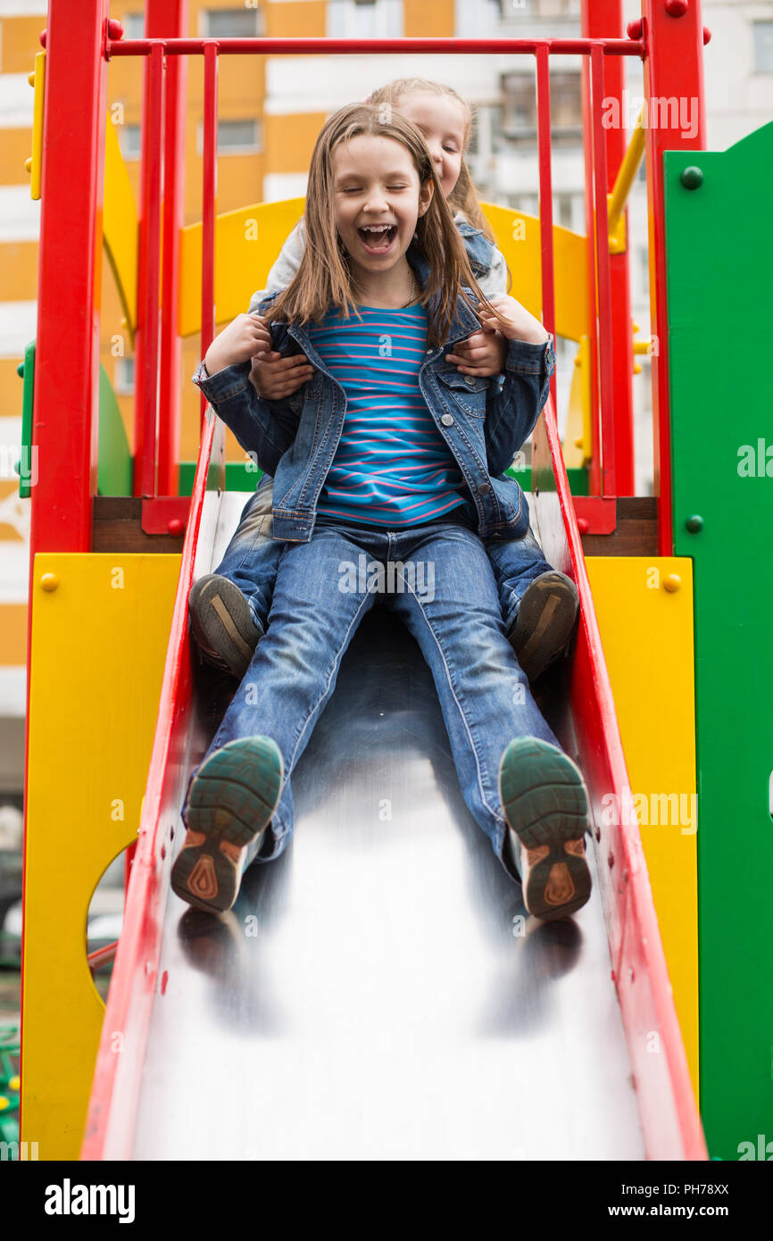 Mädchen Rutschen hinunter den Hügel auf dem Spielplatz Stockfoto