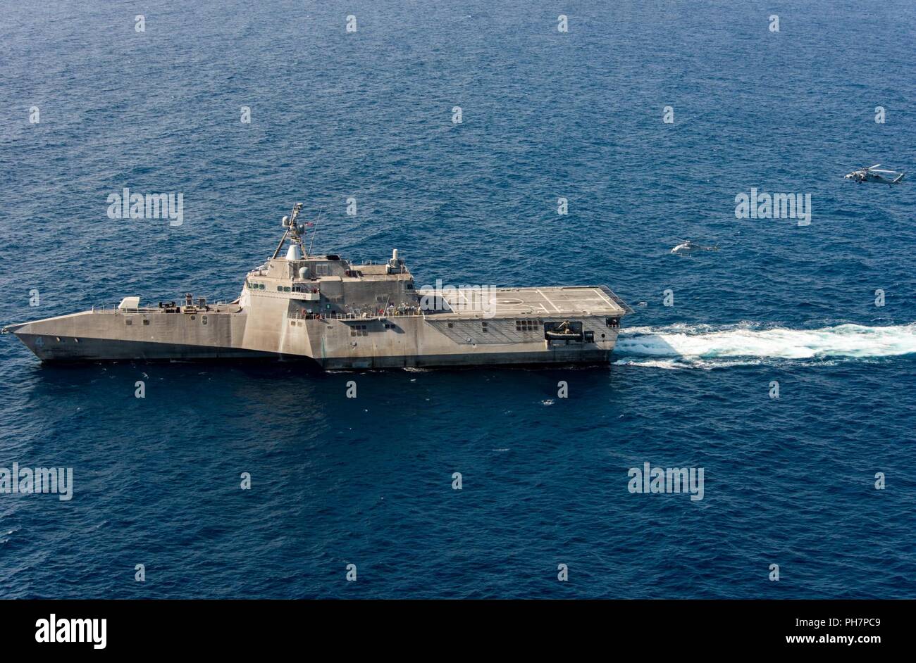 Pazifik (28. Juni 2018) - Ein MQ-8C Fire Scout unbemannte Helikopter führt derzeit mit einem MH-60S Seahawk Helikopter und die Unabhängigkeit - Variante Littoral Combat Ship USS Coronado (LCS 4). Die neuen Scout Variante erwartet wird mit der LCS-Klasse Aufklärung zu verlegen, um für das Situationsbewusstsein und Zielgenauigkeit unterstützen. Coronado ist die Arbeit mit der Prüfung und Bewertung von Staffel 1 (VX-1) Die neueste Fire Scout unbemannte Hubschrauber zu testen. Coronado ist eine von vier benannten Test Schiffe im LCS klasse Littoral Combat Ship Squadron zugewiesen. Stockfoto