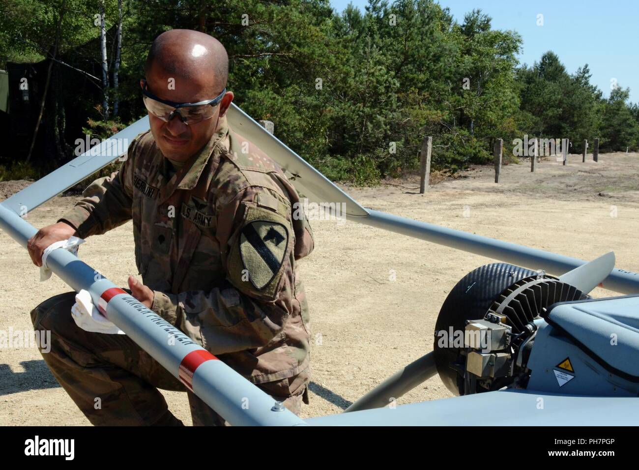 Spc. Osvaldo Gierbolini, ein unbemanntes Flugzeug system Betreuer auf den Reiter platoon Delta Firma zugewiesen, 91st Brigade Ingenieur Bataillon, 1st Armored Brigade Combat Team, 1.Kavallerie Division, reinigt die hinteren Kotflügel eines RQ-7B Shadow UAS im Reiter Flug Landeplatz in Zagan, Polen, 29. Juni 2018. Der platoon Die erste taktische UAS Flug in Polen. Sie sind derzeit zur Unterstützung der Atlantischen lösen in Europa eingesetzt. Stockfoto