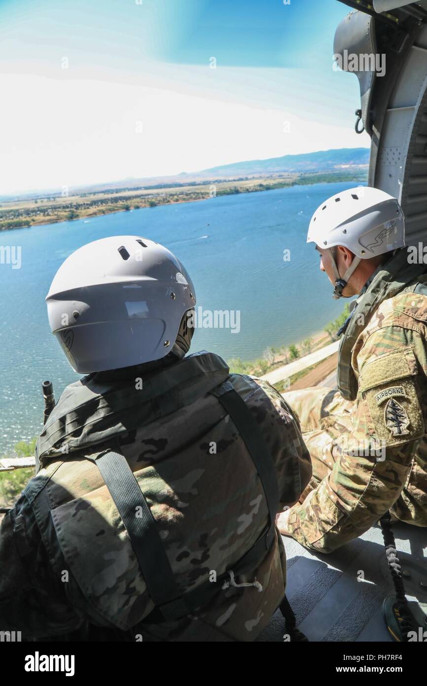Us-Armee Soldaten, zugeordnet zu den 10 Special Forces Group (Airborne), Fliegen über Chatfield Behälter während ein Helo-cast Schulungsveranstaltung in der Nähe von Littleton, Colorado, 29.06.2018. Eines der Ziele im Rahmen der Schulung erreicht war ihre Fähigkeit, aus der Luft anzugreifen sowie das Meer zu festigen. Stockfoto