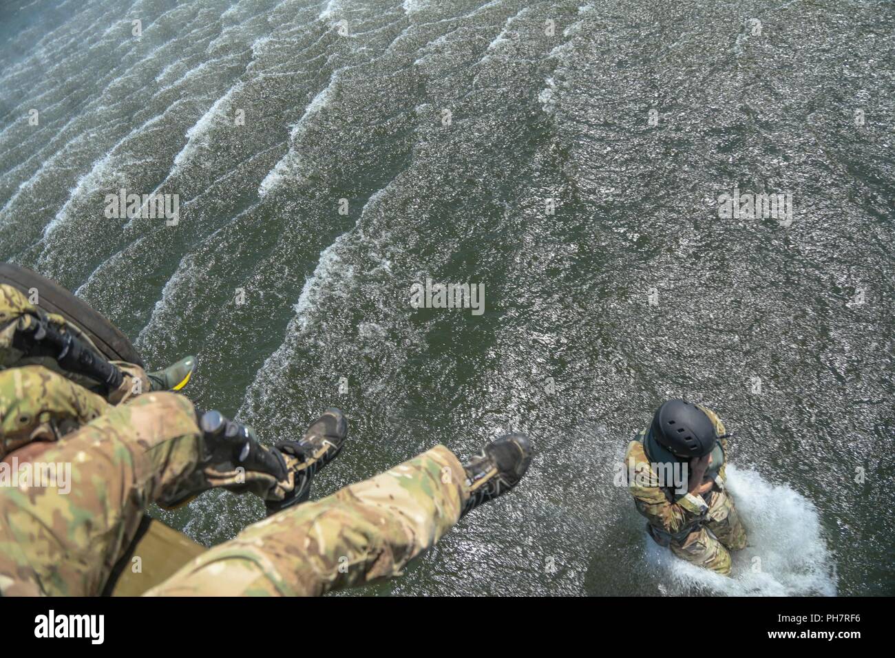 Ein Soldat der US-Armee, zugeordnet zu den 10 Special Forces Group (Airborne), springt aus einem UH-60 Blackhawk Hubschrauber in Chatfield Behälter während ein Helo-cast Schulungsveranstaltung in Littleton, Colorado, 29.06.2018. Eines der Ziele dieser Schulungsveranstaltung durchgeführt wurde ihre Fähigkeit, aus der Luft anzugreifen sowie das Meer zu festigen. Stockfoto