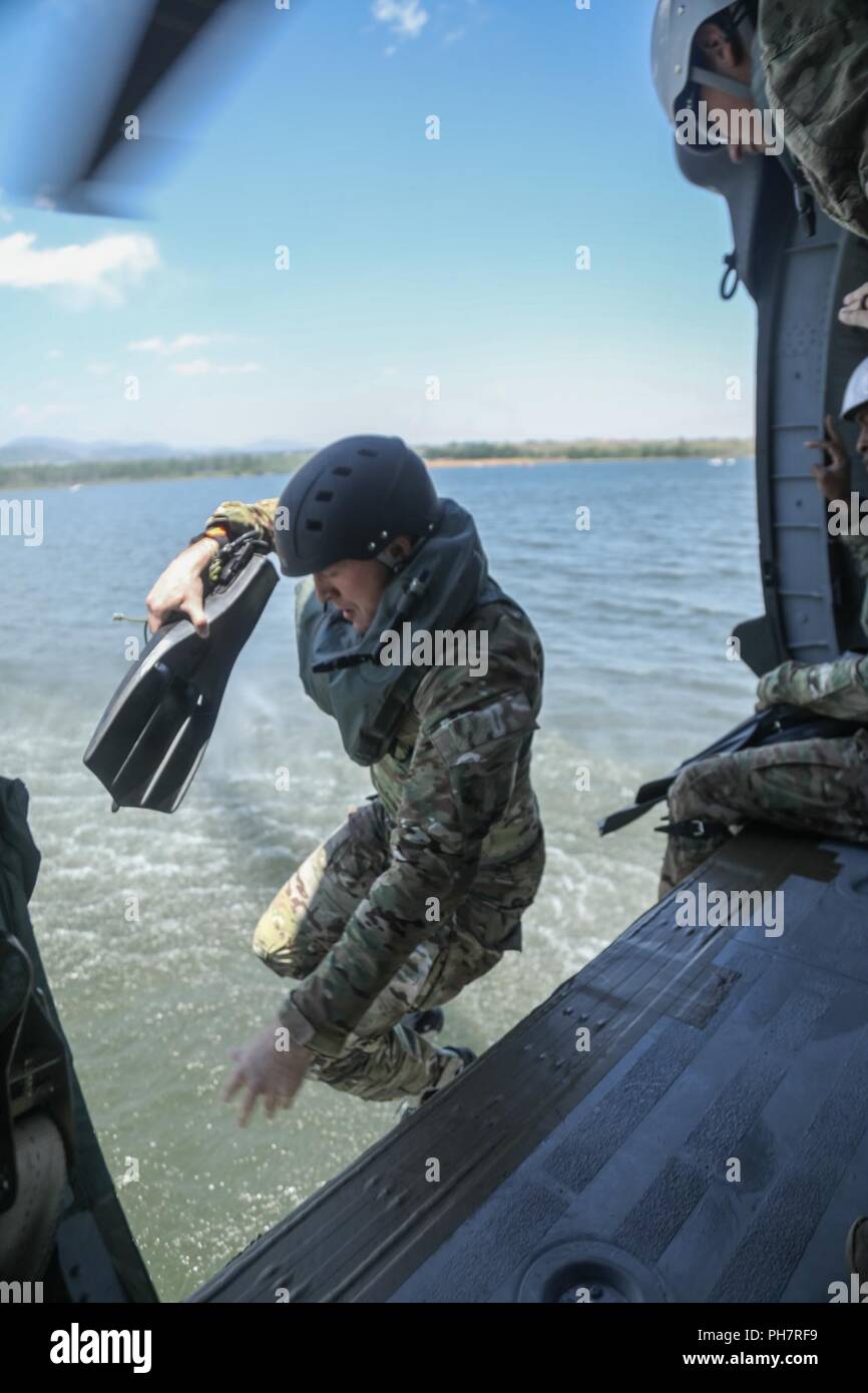 Ein Soldat der US-Armee, zugeordnet zu den 10 Special Forces Group (Airborne), springt aus einem UH-60 Blackhawk Hubschrauber in Chatfield Behälter während ein Helo-cast Schulungsveranstaltung in Littleton, Colorado, 29.06.2018. Eines der Ziele dieser Schulungsveranstaltung durchgeführt wurde ihre Fähigkeit, aus der Luft anzugreifen sowie das Meer zu festigen. Stockfoto