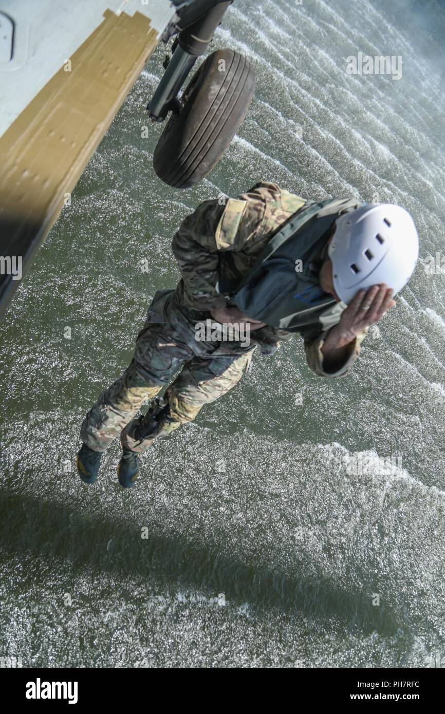 Ein Soldat der US-Armee, zugeordnet zu den 10 Special Forces Group (Airborne), springt aus einem UH-60 Blackhawk Hubschrauber in Chatfield Behälter während ein Helo-cast Schulungsveranstaltung in Littleton, Colorado, 29.06.2018. Eines der Ziele dieser Schulungsveranstaltung durchgeführt wurde ihre Fähigkeit, aus der Luft anzugreifen sowie das Meer zu festigen. Stockfoto