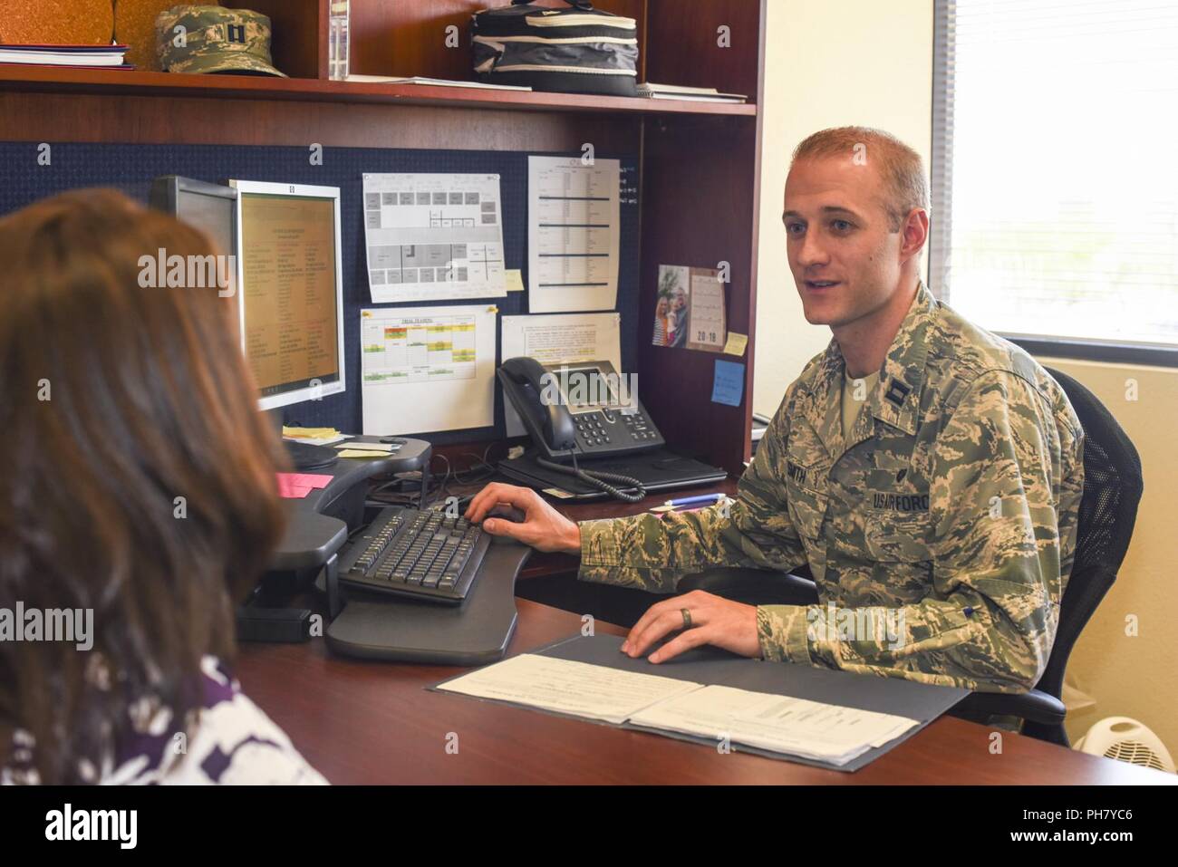 Us-Luftwaffe Kapitän Tyler Smith, 355 Fighter Wing Rechtsabteilung Personal Judge Advocate Assistant unterstützt eine militärische Ehegatte während einer unterzeichnen Veranstaltung in Davis-Monthan Air Force Base, Ariz., 27. Juni 2018. Dieses Ereignis geschieht monatlich und ist ein kostenloser Dienst, Pensionäre in die Tucson Gemeinschaft. Stockfoto