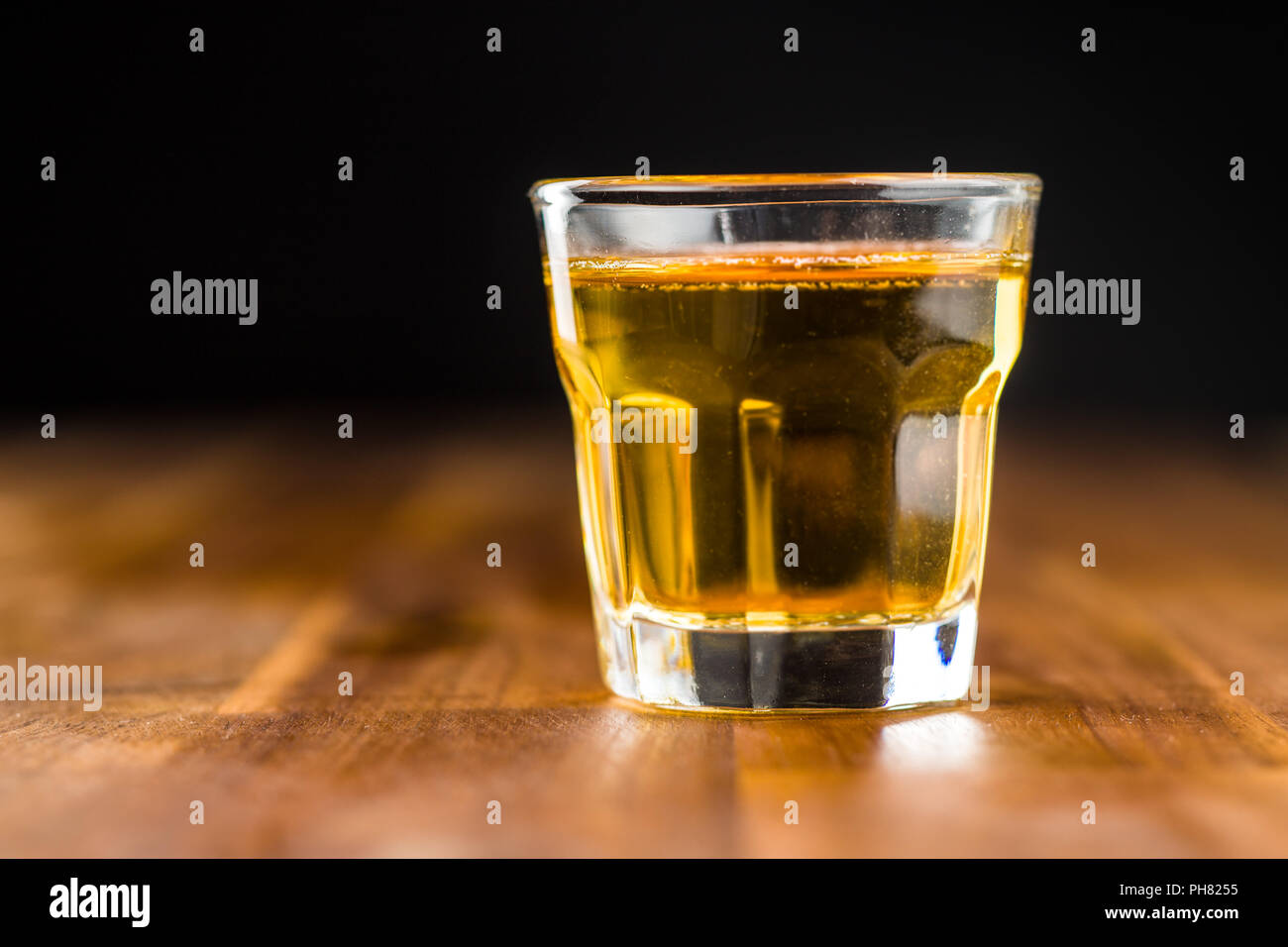 Glas alkoholische Getränk auf Holztisch. Whiskey in Glas. Stockfoto