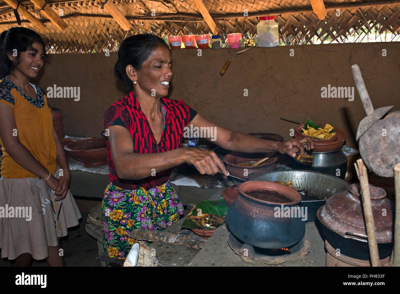 Horizontale Bildnis einer Dame mit ihrer Tochter, wie traditionelle Sri Lanka Essen zu kochen. Stockfoto