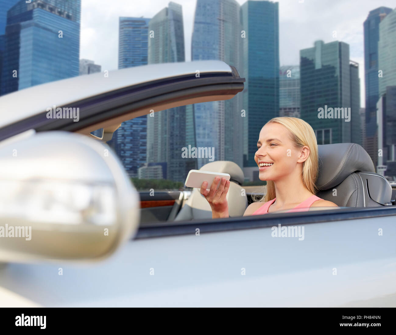 Frau mit Smartphones im Auto über Singapur Stadt Stockfoto