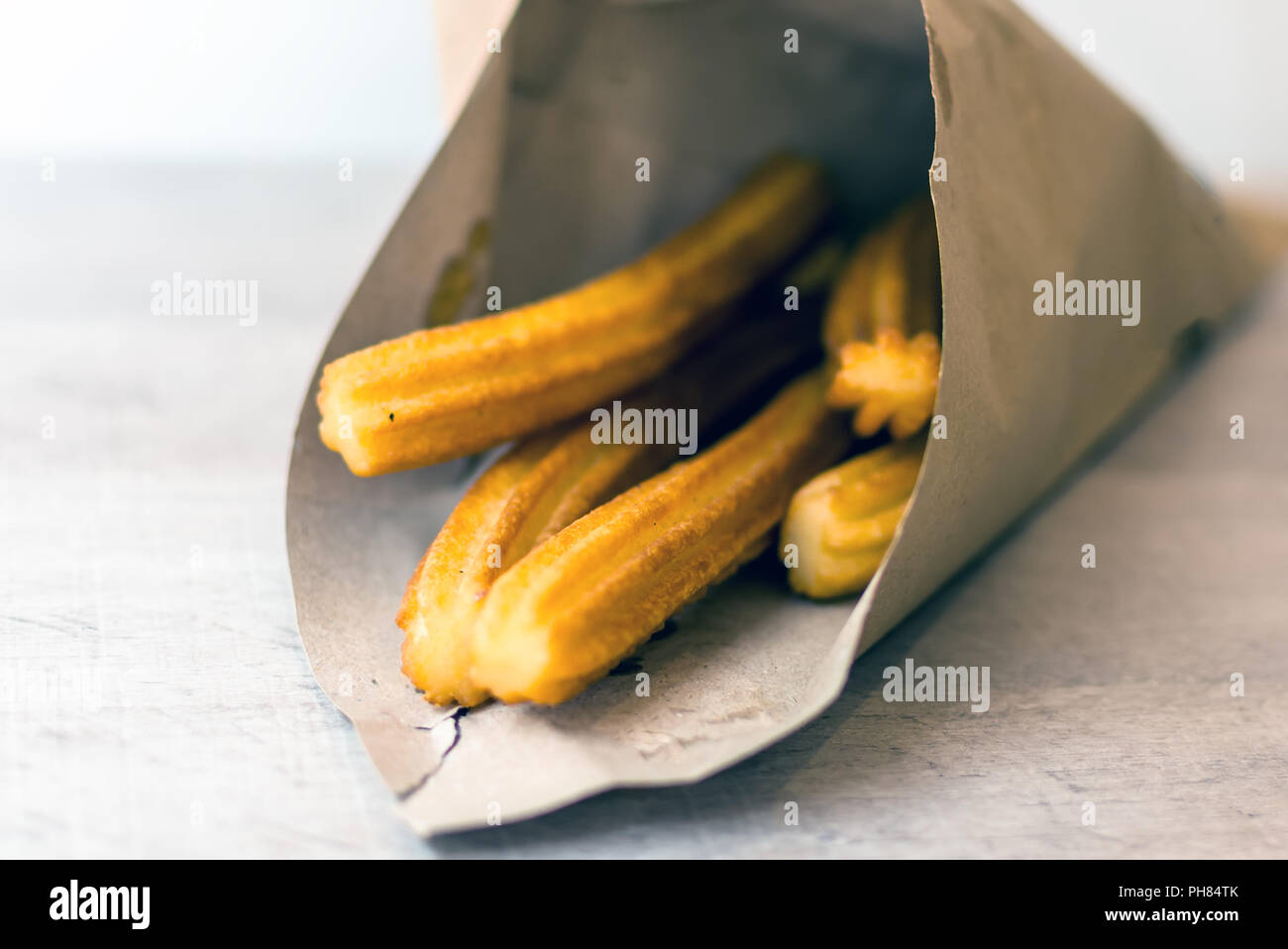 Traditionelle spanische Dessert Churros in braunem Papier Kegel. Ein churro ist ein gebraten - Teig Gebäck basierte Snack. Seine Oberfläche ist Ridged Wegen geleitet. Stockfoto