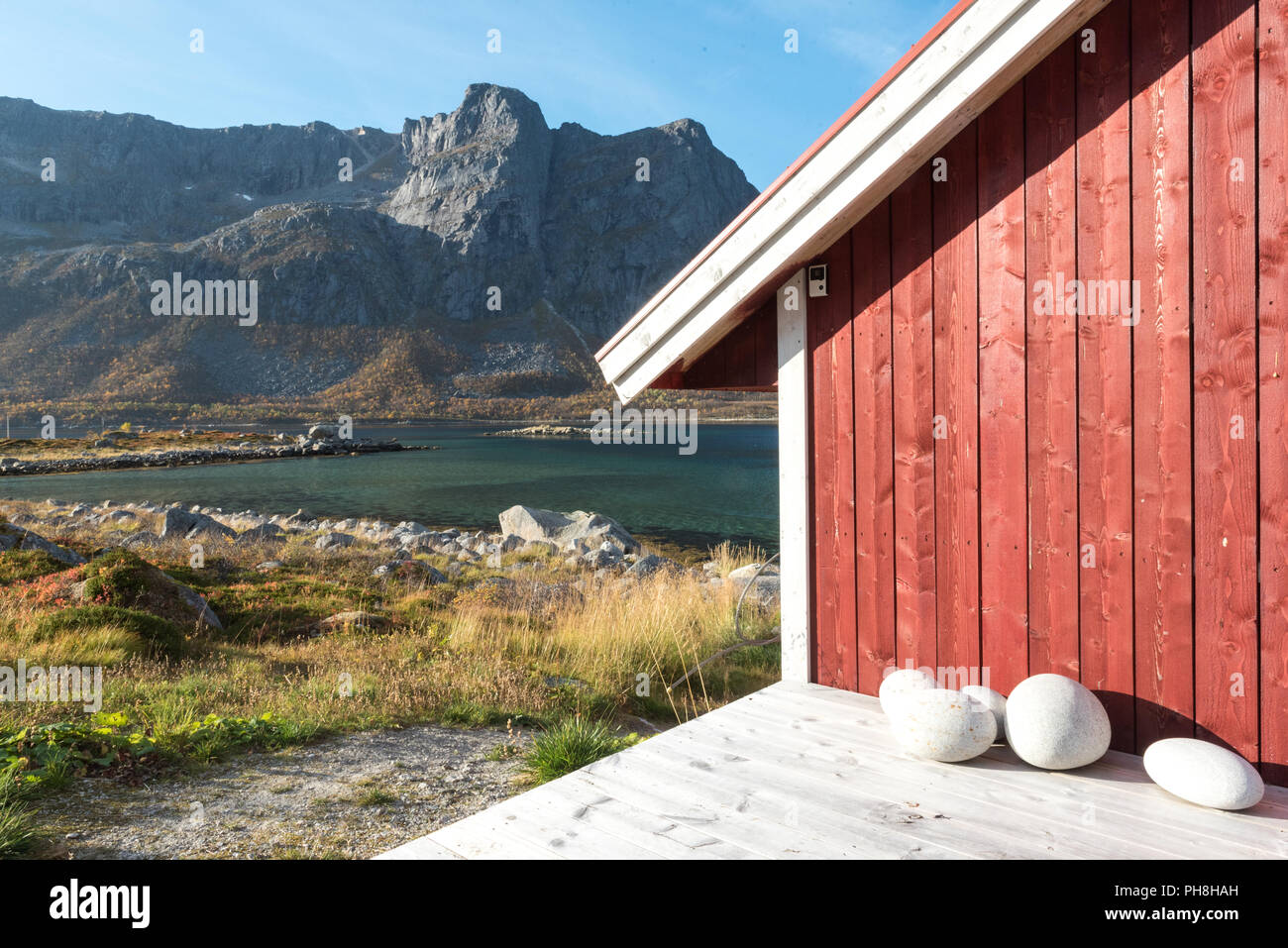 Close up 7/8-Ansicht einer Holz- Norwegische Beach Hut mit Steinen am Ufer mit Blick auf den Oslo Fjord, Polarkreis, Norwegen und Berg pe Stockfoto