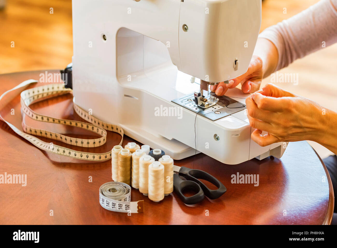 Schneiderin oder Näherin arbeitet mit Nähmaschine. Rollen, Schere, Maßband  und eine Nähmaschine. Arbeitsplatz Stockfotografie - Alamy