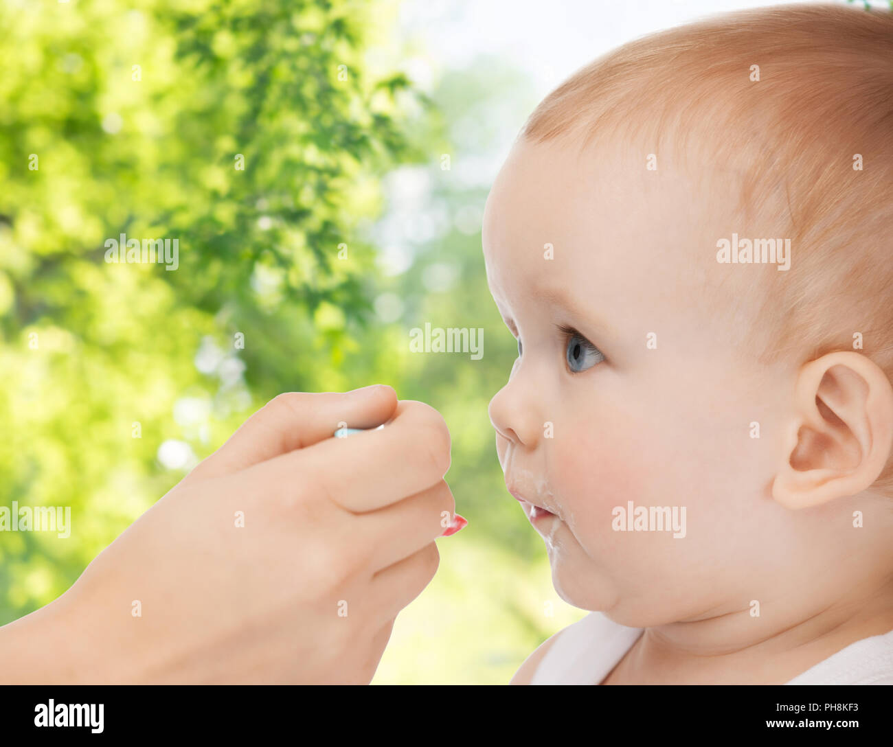 Mutter hand mit Löffel füttern Baby Stockfoto