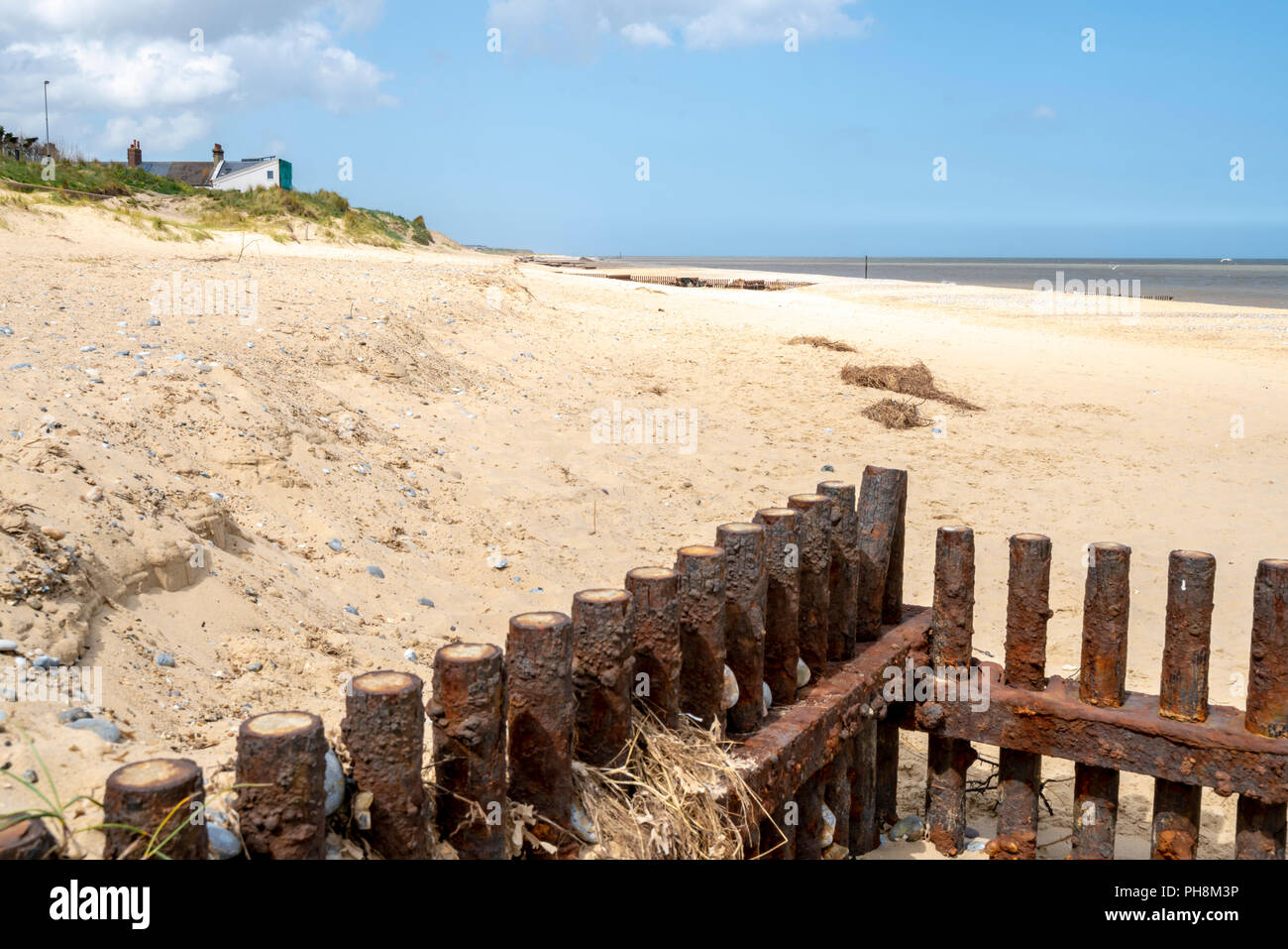 Rostigem Eisen Sturm und Erosion Verteidigung Barrieren auf einem sandigen Strand von Norfolk in Großbritannien Stockfoto