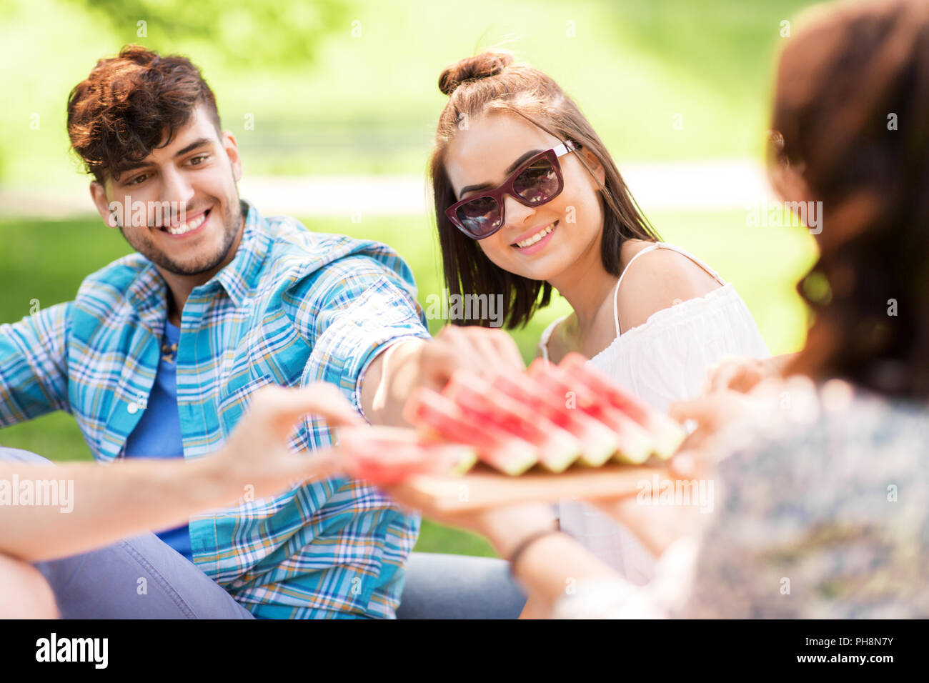 Gerne Freunde essen Wassermelone im Sommer Picknick Stockfoto