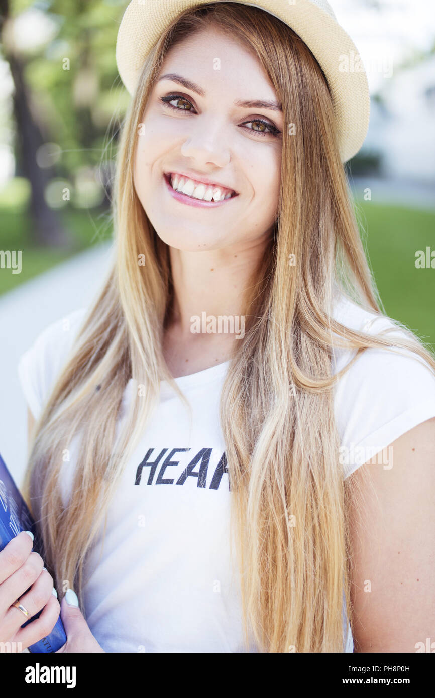 Hübsche blonde Frau mit Hut mit Buch Stockfoto