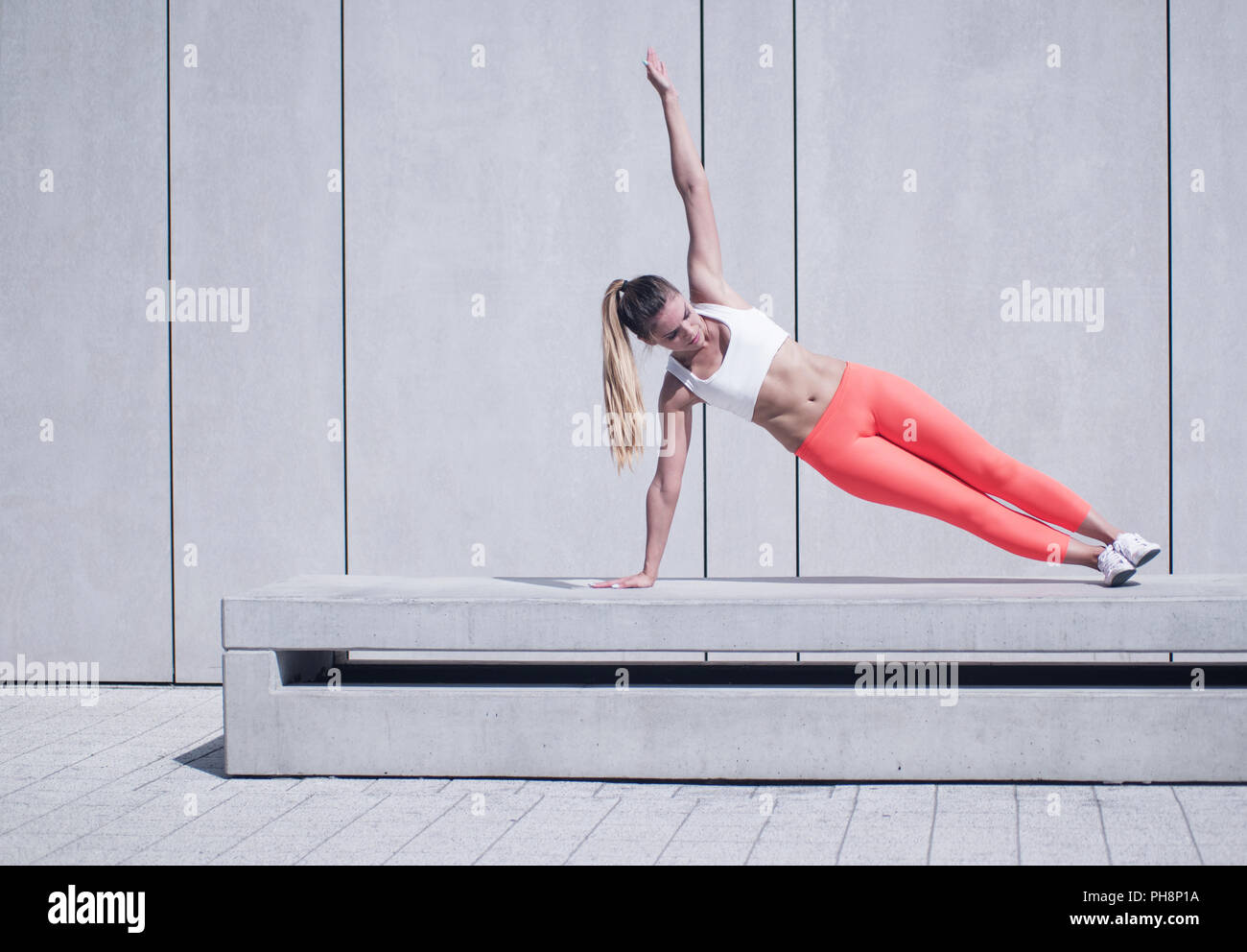 Sportliche Frau Seite Plank Übung auf Plattform Stockfoto