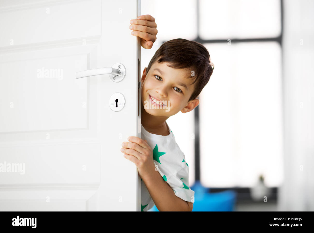 Happy little boy hinter die Tür zu Hause Stockfoto