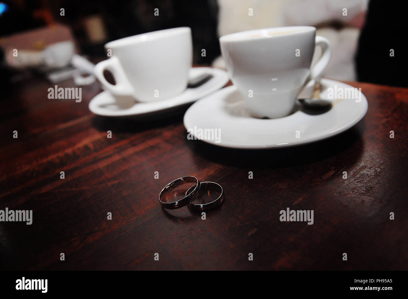 zwei silberne Hochzeitsringe Hintergrund Tassen Kaffee Stockfoto