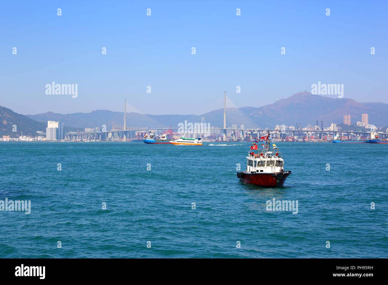 Boote in den Hafen von Hong Kong und Stonecutters Brücke Stockfoto