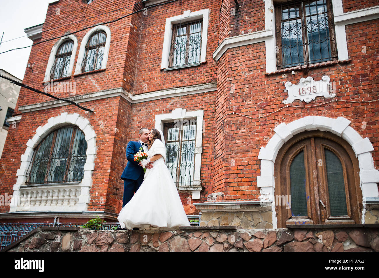 Hochzeitspaar in Liebe Background alten Backstein-Haus Stockfoto