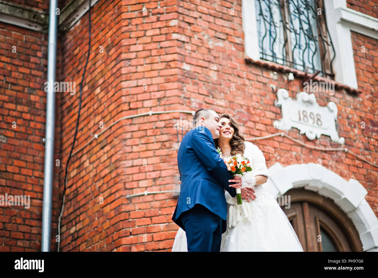 Hochzeitspaar in Liebe Background alten Backstein-Haus Stockfoto