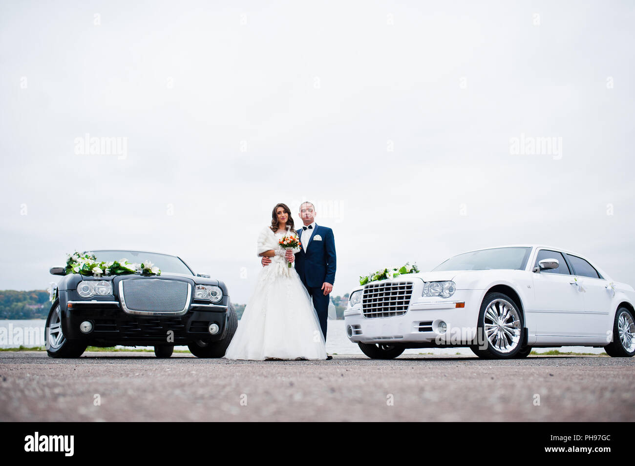 Hochzeitspaar Hintergrund zwei schwarze und weiße Hochzeit Autos Stockfoto