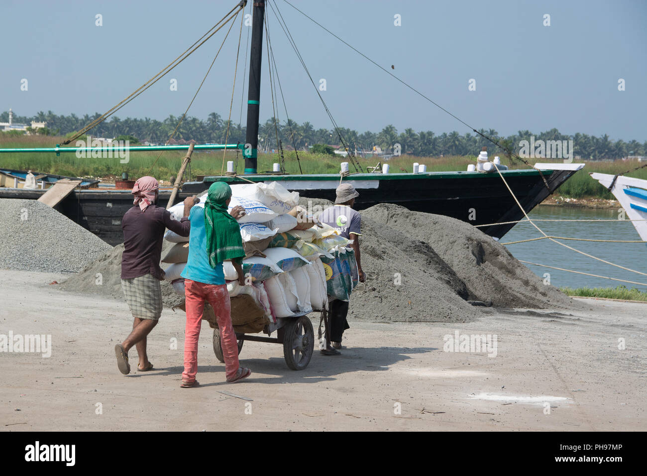 Mumbai, Indien - 8. Juli 2018 - die indischen Arbeiter entladen Säcke mit Sand vom Schiff im Hafen für eine Baustelle Stockfoto