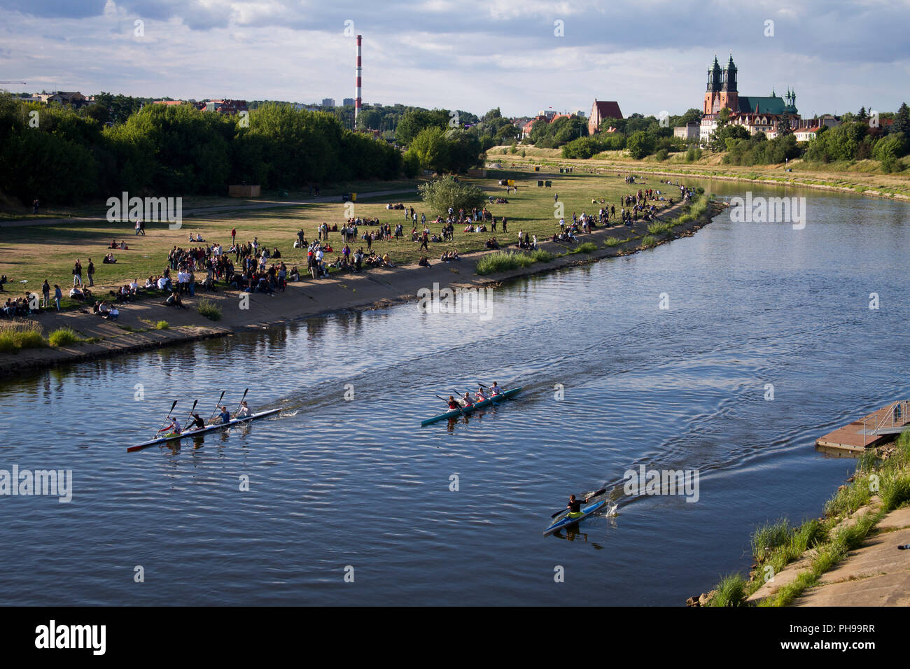 Junge Menschen während ihrer Ruhe auf der Warthe in Posen. Die Dominsel (Ostrów Tumski) im Hintergrund. Stockfoto