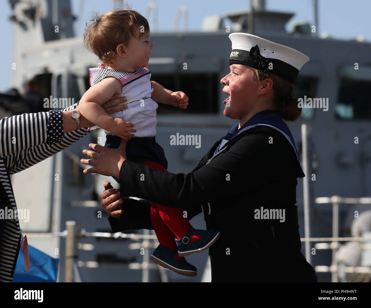 Vollmatrosen, Robyn Lockwood (19) mit ihrer Nichte Florenz Slade (14 Monate) nach kam sie zurück nach Bereitstellung mit der Royal Navy mein Hunter HMS Bangor, die in den Golf serviert wurde, wie das Schiff zu HM Naval Base Clyde zurück. Stockfoto